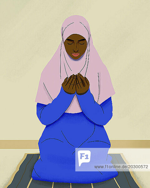 Muslim woman in hijab praying on mat