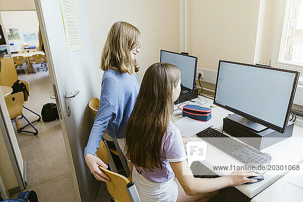 Studentinnen surfen am Computer am Schreibtisch im Klassenzimmer im Internet