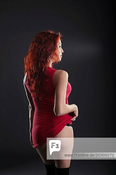 Sexy rothaarige Frau posiert mit dem Rücken zur Kamera  Nahaufnahme