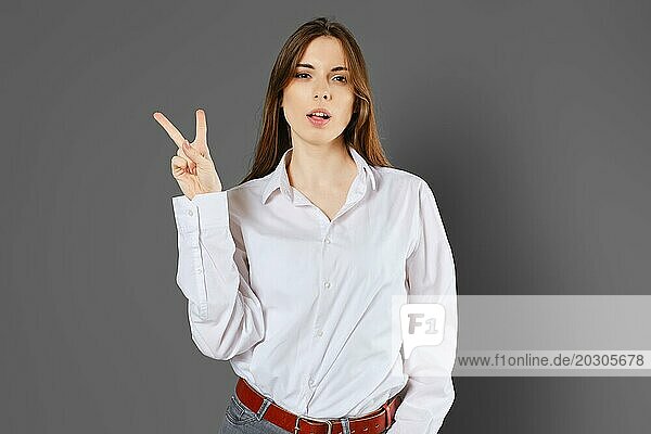 Junge Frau zeigt zwei Finger oder Siegeszeichen. Zählen mit Fingern Konzept
