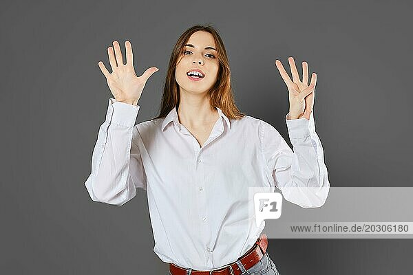 Inspirierte junge Frau zeigt neun Finger. Zählen mit Fingern Konzept
