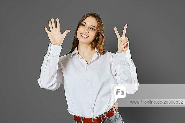 Verspielte Frau zeigt sieben Finger. Zählen mit Fingern Konzept