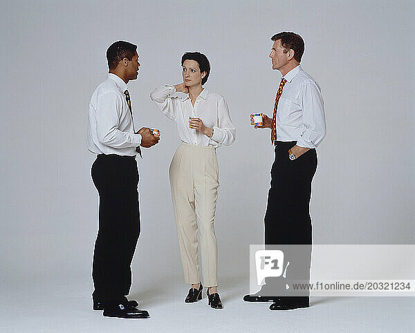 Business & Professions. Two young men & a young woman taking a coffee break indoors.