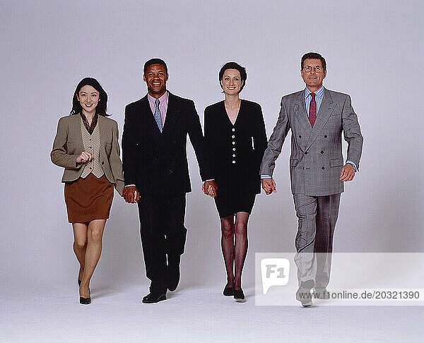 Business & Professions. Team of four people confidently walking ahead.