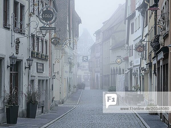 Street with town houses in the historic old town in the morning fog  Rothenburg ob der Tauber  Middle Franconia  Bavaria  Germany  Europe