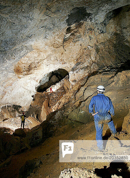 Cave explorers illuminate a passage in a cave in Mulu National Park