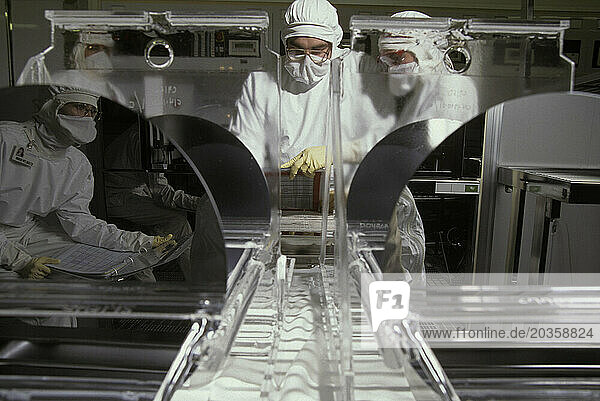 Two researchers work at a semi-conductor research facility.