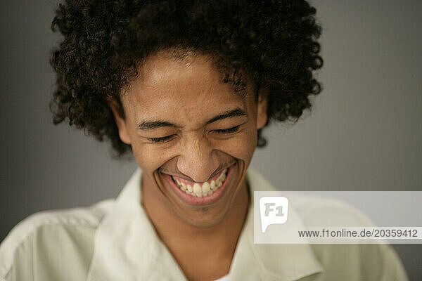 African American man smiles and laughs.