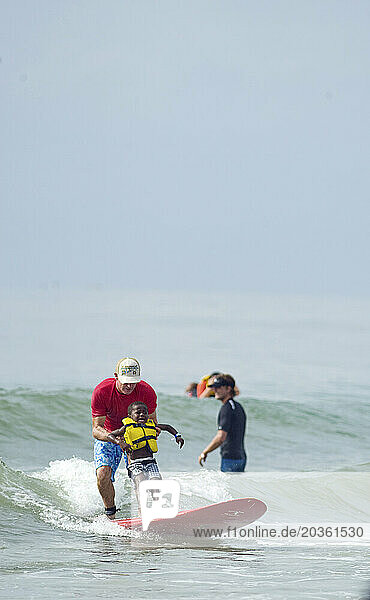 Surfer's Healing with Autistic children riding waves at Wrightsville Beach  NC