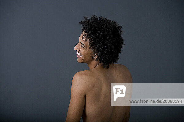 African American man without shirt smiles.