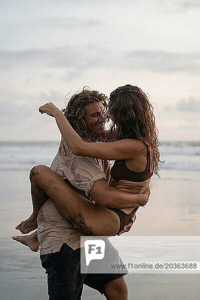Young cheerful happy couple in love fooling around on the beach.