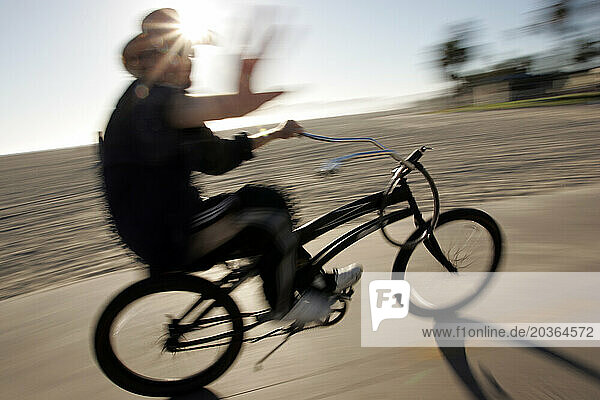 A man rides his Beach Cruiser on a bike lane in Venice  California. (blurred motion)