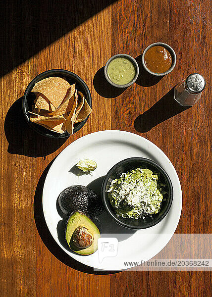 Overhead shot of avocado and guacamole in round bowls