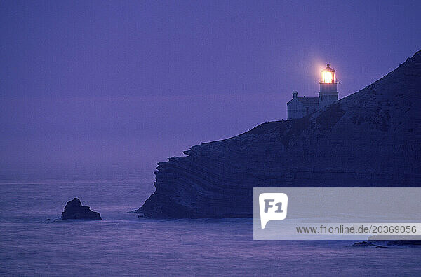 Light shines from the Point Conception Lighthouse on coast of California.