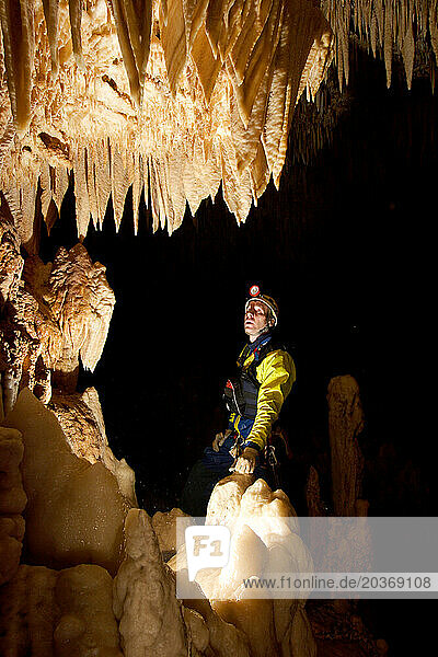 A cave explorer admires pretty formations in a cave in New Britain