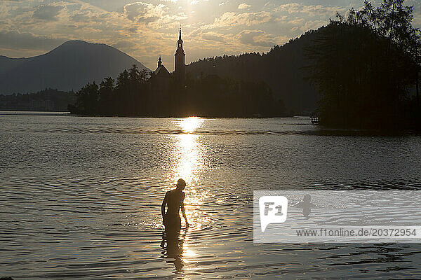 Two boys swimming in Lake Bled at sunset  Bled  Upper Carniola  Slovenia