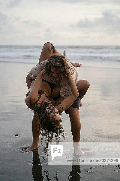 Young cheerful happy couple in love fooling around on the beach.