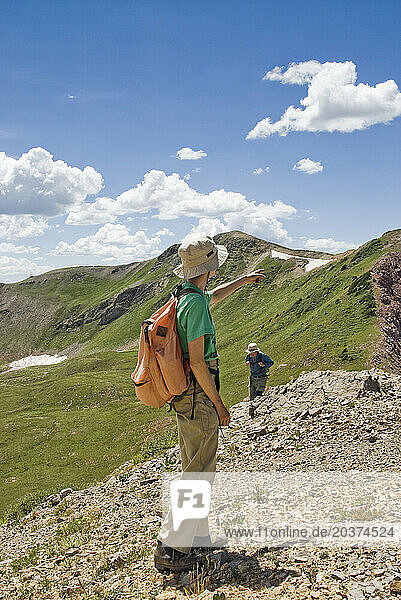 A man and a woman day hike in the Snowmass-Maroon Bells Wilderness  CO.