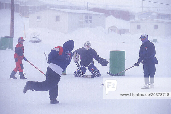 Children playing hockey in street  Igloolik  Nunavut  Canada