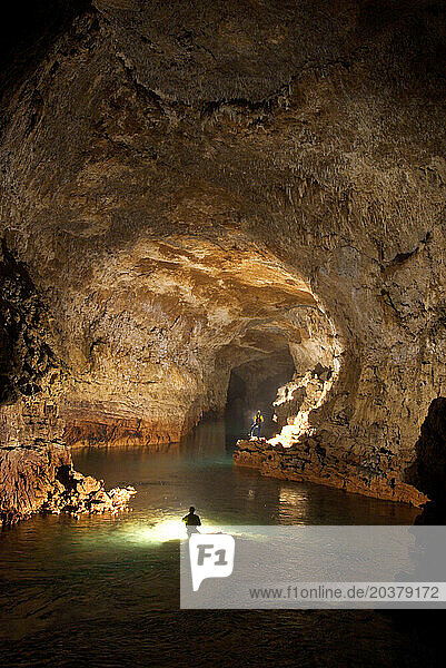 Cave explorers illuminate a giant river passage underground in New Britain