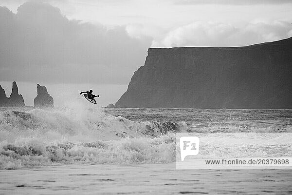 Surfer doing a frontside air in Iceland. Cold water