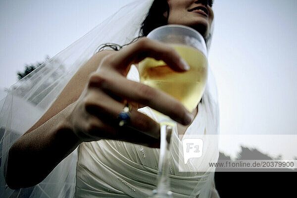 A bride with a glass of wine.