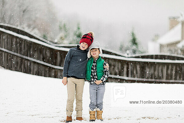 Two brothers playing in the backyard in the snow