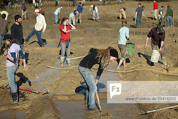 Farmers Digging in the mud to create Rice Paddies.