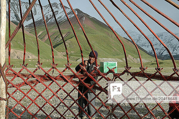 Man constructing framework for a yurt in Kyrgyzstan.