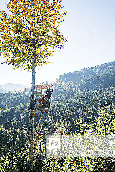 Senior man looking at forest from observation tower