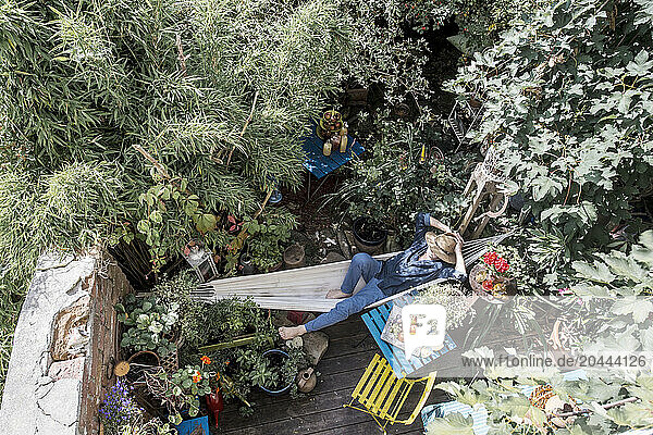 Man resting on hammock in back yard garden