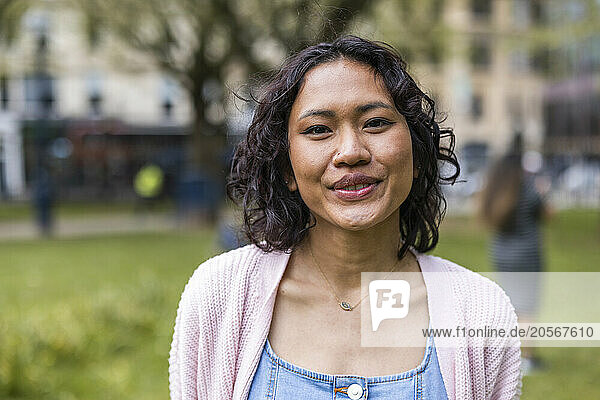 Smiling woman wearing sweater at park