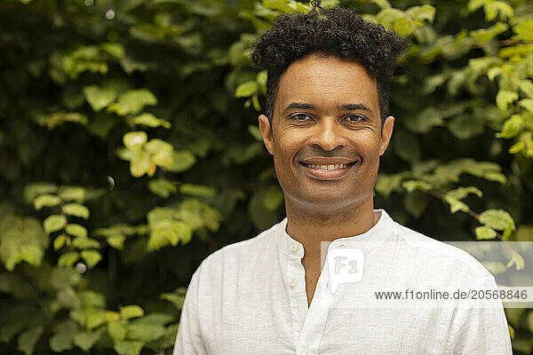 Smiling curly hair man in white shirt