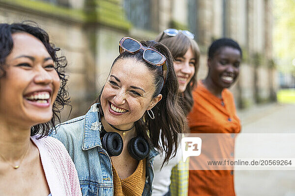 Cheerful multiracial women standing together