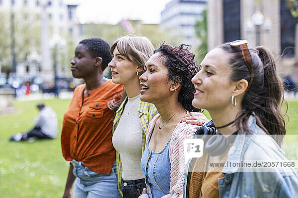 Multiracial friends walking side by side at park