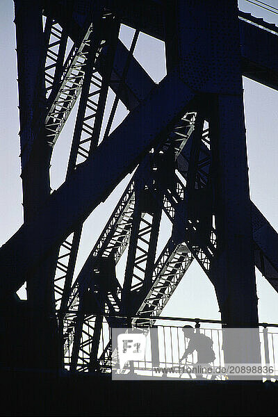 Australia. Queensland. Brisbane. Silhouette of lone cyclist on the Story Bridge.