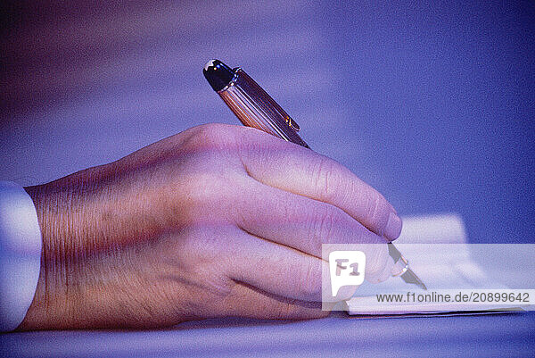 Business & Professions. Close up of man s hand  writing with fountain pen.