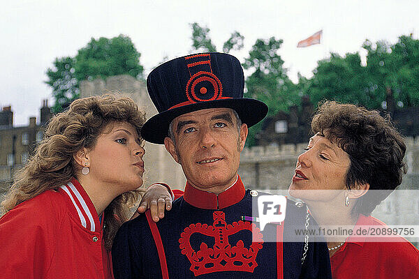 England. London. Beefeater with tourists. The Tower of London.
