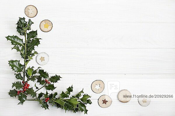 Natural Christmas background. Traditional Christmas holly with red berries on white wood background. Copy space Top view. Christmas frame
