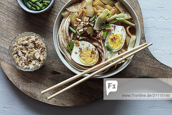 White cabbage soup with miso and udon noodles and boiled eggs and peanuts as topping