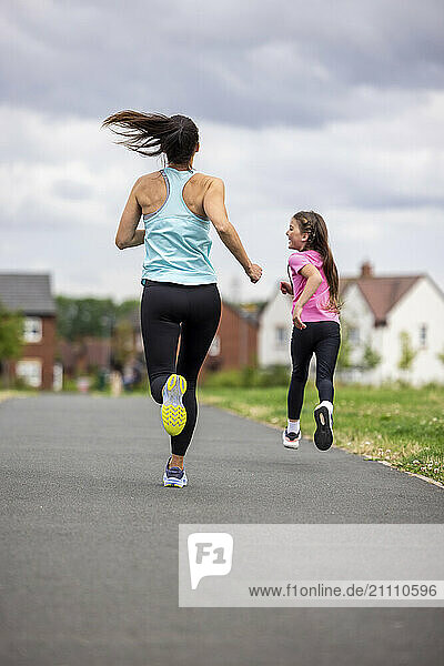 Mother running with daughter on road