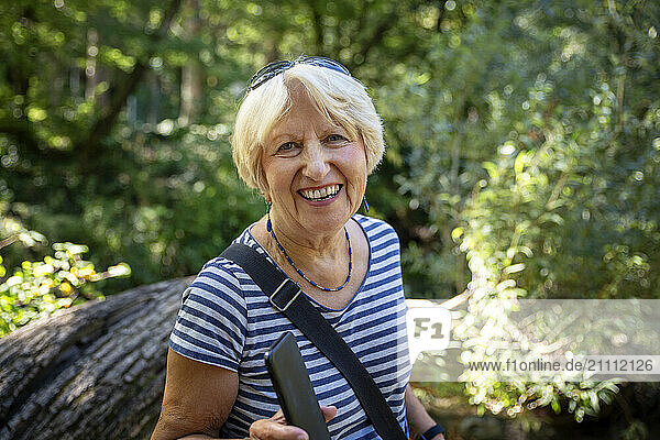 Senior woman in the Cetina valley  Dalmatia  Croatia  laughing and holding a smartphone.
