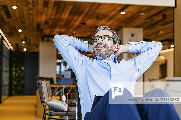 Relaxed businessman sitting at co working space