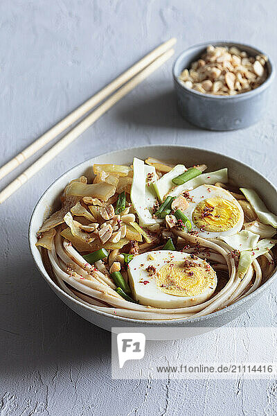 White cabbage soup with miso and udon noodles and boiled eggs and peanuts as topping