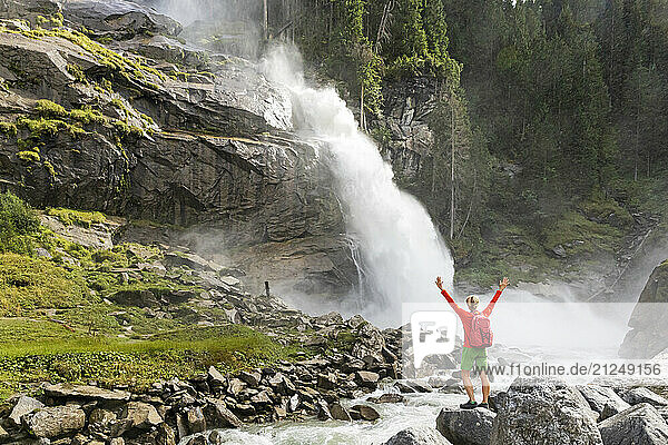 Hiker cheering at Krimml Waterfalls in Hohe Tauern National Park  Austria.