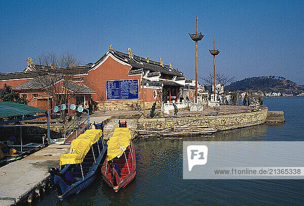 China. Zhejiang. Ningbo. Dongqian Lake. Waterfront scene with buildings and boats.