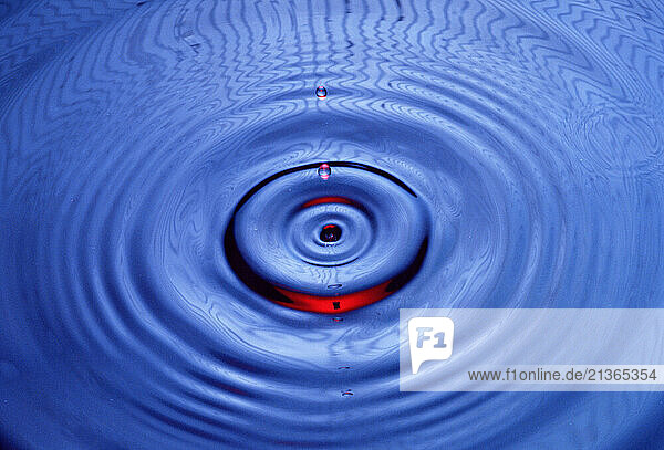 Art photograph. Close up of water splash droplet with concentric circle ripples.