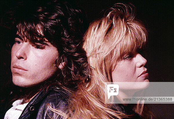 Close-up head & shoulders of young man & woman couple.
