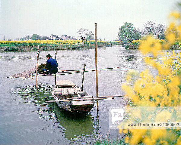 China. Jiangxi Province. Gan River. Local fisherman making canopy for his rowing boat.