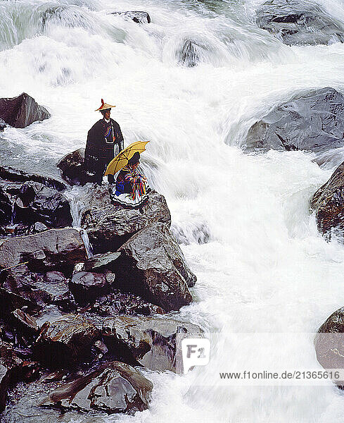 China. Sichuan Province. Couple in traditional clothes by Pearl Shoal waterfall.